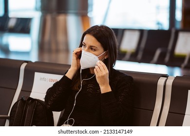 Tourist Woman At The Airport Waiting For Her Flight. Wearing A Mask For Covid 19 Protection Doing A Videocall With Her Tablet. Lifestyle. Travel