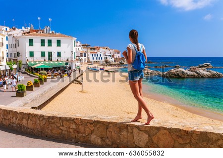 Tourist woman in Calella de Palafrugell, Catalonia, Spain near of Barcelona. Scenic fisherman village with nice sand beach and clear blue water in nice bay. Famous resort destination in Costa Brava