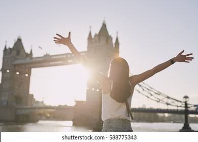 Tourist Woman Celebrates Arms Raised At Tower Bridge Destination Sunset In London On Adventure Travel Vacation