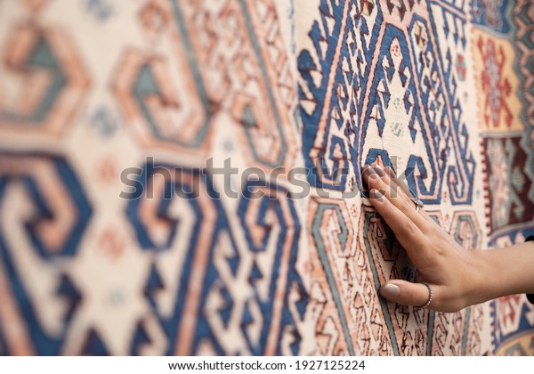 Tourist woman chooses Turkish rug at the\
bazaar.Traditional turkish rug\
shop.