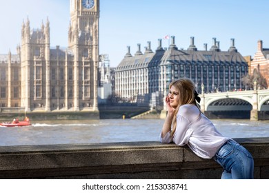 A tourist woman in front of the Big Ben tower in London during her city sightseeing trip