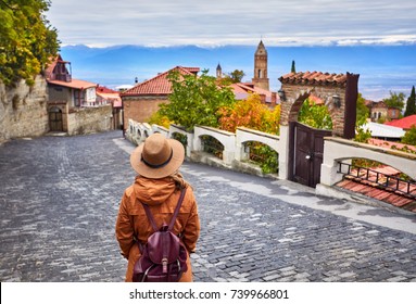 Tourist woman in Hat with backpack at the street of Signagi town in Georgia
