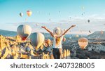 tourist woman looking at hot air balloons in Cappadocia, Turkey- Travel, tourism concept	