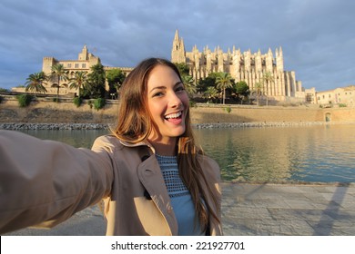 Tourist woman photographing a selfie in Palma de Mallorca Cathedral on holidays