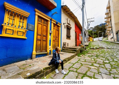 Tourist woman sitting on a street in La Candelaria, Bogota, Colombia - Shutterstock ID 2320386155