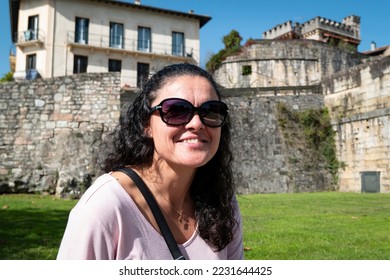 Tourist woman sitting in the park with a beautiful smile on her face - Shutterstock ID 2231644425