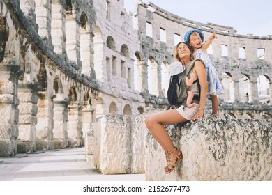 Tourist woman with small kids in Roman Amphitheater Arena like as Coliseum - famous travel destination in Pula, Croatia. Happy mother and children on vacation in Europe. Family Active Travel.