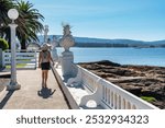 Tourist woman strolling by the sea on the island of La Toja on a sunny day, Galicia.