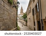 Tourist woman walking through the narrow streets of the historic center of Santiago de Compestela, Galicia.