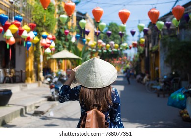 Tourist woman is wearing Non La (Vietnamese tradition hat) and enjoy sightseeing at Heritage village in Hoi An city in Vietnam.