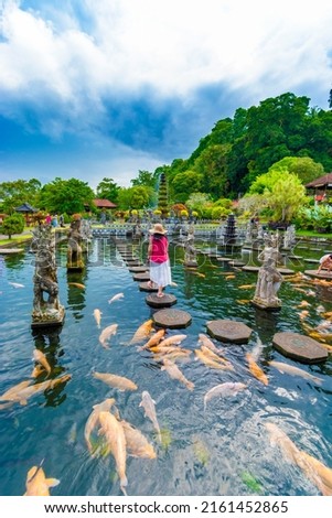 Tourist women wearing hat on holidays at Water Palace of Tirta Gangga in East Bali, Indonesia