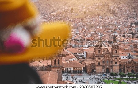 Tourist with woolen hat on San Cristobal viewpoint looking the main square of Cuzco. Peru