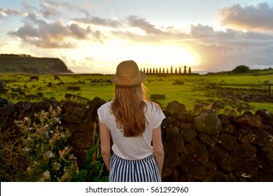 Tourist Young Woman Girl In Hat  Looking On Sunrise And Ahu Tongariki On Easter Island, Chile