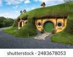 Touristic complex Boierul Ilie in Cisnadioara with unusual yellow house and green grass roof. Look like the hobbit