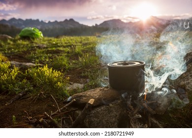 Touristic kettle on fire of burning campfire in camping in the hike. Cooking food in forest on wooden firewood. - Shutterstock ID 2180721949