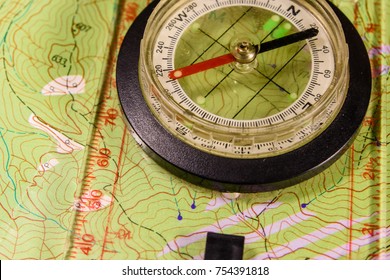 Touristic Magnetic Compass Lying On Topographical Map