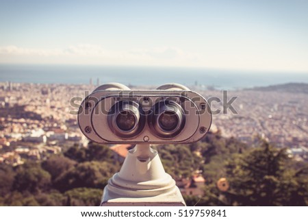 Touristic telescope look at the city Barcelona Spain, close up metal binoculars on background viewpoint overlooking the mountain, hipster coin operated in panorama observation blue sky