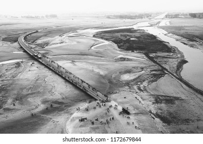 Tourists Arriving (walking,by Shuttle Bus, Or In Horse Carriage) To Visit The Famous Mont Saint Michel Abbey.  France. Aerial View From The Walls. Black And White Photo.