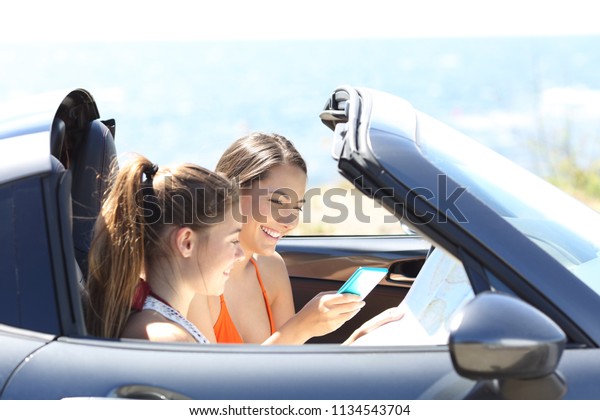 Tourists in a convertible car searching\
destination online on summer\
vacation