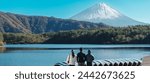 tourists enjoy with Fuji Mountain at Lake Saiko, happy friends group travel Mount Fuji and road trip Fuji Five Lakes. Landmark for tourists attraction. Japan Travel, Destination and Vacation concept