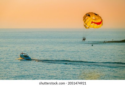 The Tourists Enjoys Parasailing At The Beach