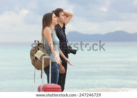 Tourists frustrated with the bad weather when arrive to the beach with the cloudy sky in the background
