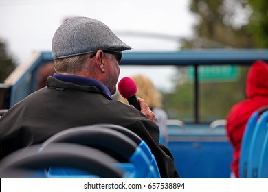 Tourists And A Host On A Hop On Hop Off Open Top Bus