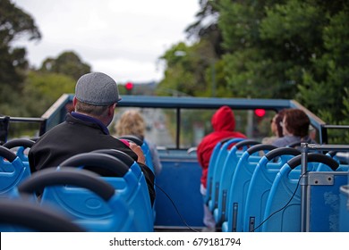 Tourists And A Host On A Hop On Hop Off Open Top Bus