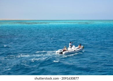 Tourists with instructor ride motor boat on Red Sea on sunny day. Coral reefs are visible in distance. Vacation in Egypt, holidays, resort, leisure and adventure, travel. Hurghada, Egypt -October 2021
