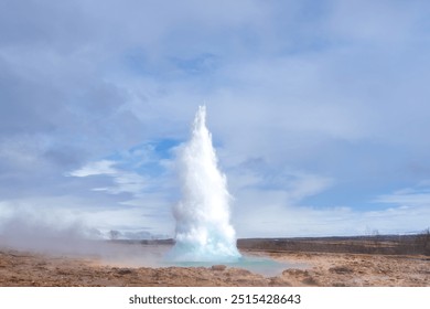 Tourists marvel at the Strokkur geyser erupting, sending a plume of steam and water high into the air. This geothermal wonder is a popular attraction in Iceland. Geysir Geothermal Area, Iceland. - Powered by Shutterstock