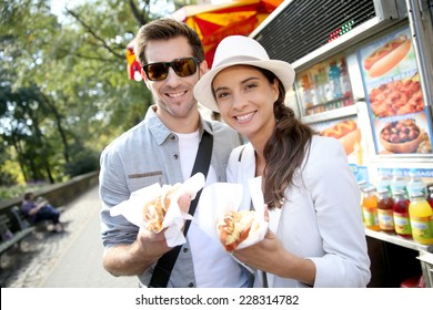Tourists in New York city eating hot dogs