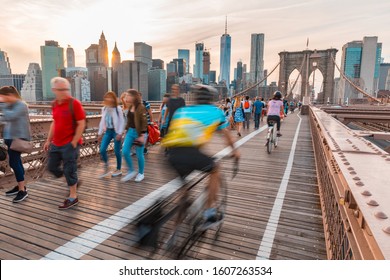 Tourists In New York On Brooklyn Bridge With Manhattan Skyscrapers On Background - Long Exposure View On The Bridge With Blurred People And Downtown Manhattan Skyline - Travel And Architecture