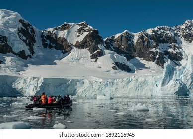 Tourists Observing A Glacier On The Antarctica, Paradise Bay, Antartica.