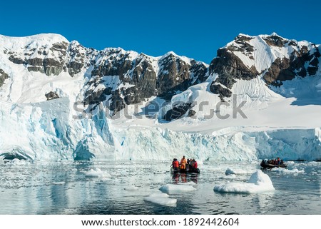 Tourists observing a glacier on the Antarctica, Paradise bay, Antartica.