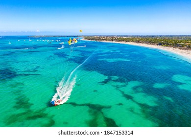 Tourists Parasailing Near Bavaro Beach, Punta Cana In Dominican Republic. Aerial View Of Tropical Resort