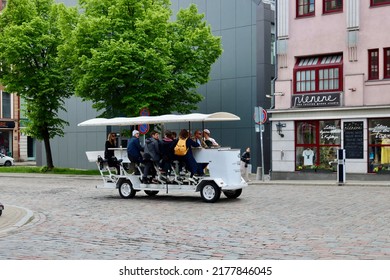 Tourists Pedalling In A Sightseeing Beer Mobile On Cobbled Street In Riga, Latvia - May 28, 2022