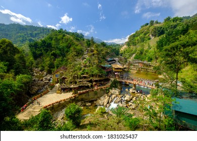 Tourists pose for photos on a bridge over a waterfall at the bottom of the indigenous Hmong Cat Cat village in northern Vietnam