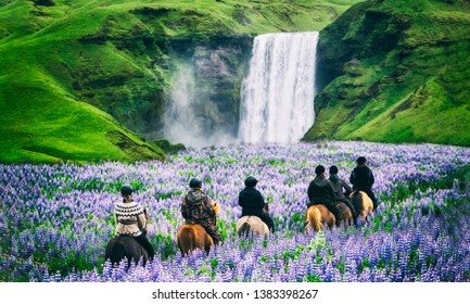 Tourists ride horses at the majestic Skogafoss Waterfall in countryside of Iceland in summer. Skogafoss waterfall is top famous natural landmark and travel destination place of Iceland and Europe.