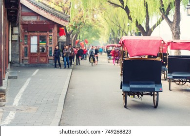 Tourists Riding Beijing Traditional Rickshaw In Old China Hutongs In Beijing, China. Landscape And Culture Travel, Or Historical Building And Sightseeing Concept