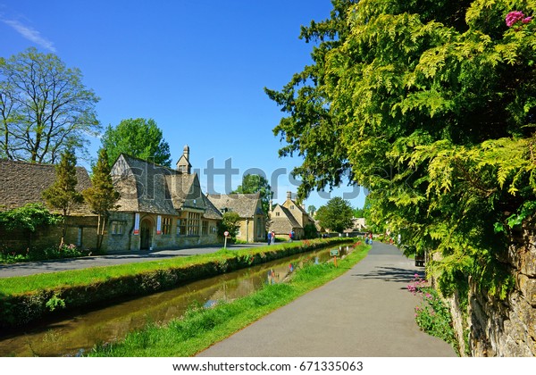 Tourists sight seeing on a beautiful summers day in the\
popular destination of Lower Slaughter,The Cotswolds,\
Gloucestershire, U K