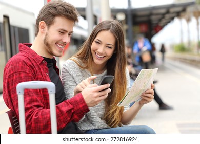 Туристы путешественники консультируются GPS и гид со смартфона на вокзале