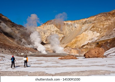 Tourists trekking at Mutnovsky volcano.  Smoking fumarolic field. South Kamchatka Nature Park, Kamchatka Krai, Russia