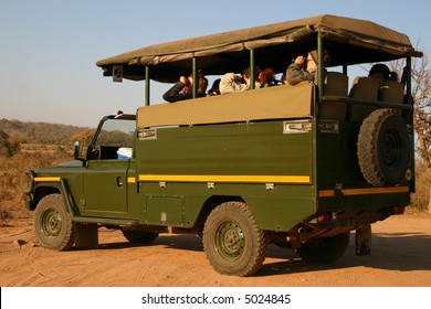 Tourists Viewing Game From An Open Safari Vehicle.