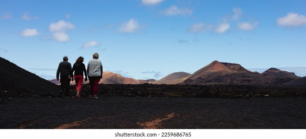 Tourists visiting volcanic landscape of Timanfaya National Park in Lanzarote. Popular touristic attraction in Lanzarote island, Canary Islands, Spain - Shutterstock ID 2259686765