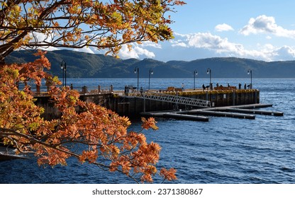 Tourists walking along a pier at sunset in Sainte-Rose-du-Nord, Province of Quebec, CANADA. Fall colors foliage.