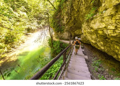 Tourists wearing helmets are walking down wooden stairs along the radovna river in vintgar gorge, a popular tourist destination near bled, slovenia - Powered by Shutterstock