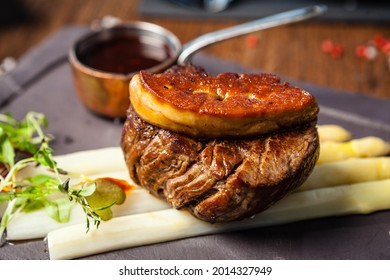 Tournedos Rossini. Foie Gras, Black Angus Beef Tenderloin, White Asparagus, Red Wine Sauce. Delicious Healthy Traditional Food Closeup Served For Lunch In Modern Gourmet Cuisine Restaurant.