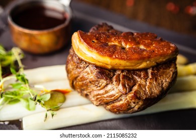 Tournedos Rossini. Foie Gras, Black Angus Beef Tenderloin, White Asparagus, Red Wine Sauce. Delicious Healthy Traditional Food Closeup Served For Lunch In Modern Gourmet Cuisine Restaurant.