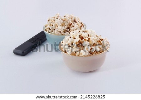Tow bowl of snack with TV remote and gray background