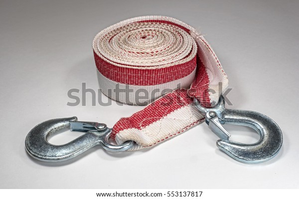 Tow rope to the car on a light background.
Rope folded in circle hooks are
nearby.